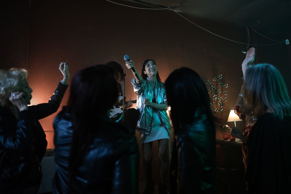 Illustrative photo of a singer holding a microphone with an audience at a karaoke-style bar performance; not MOTR Pub