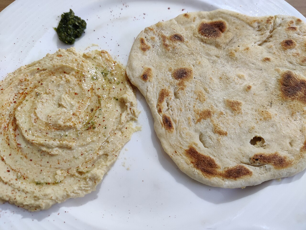 Illustrative hummus served with pita bread photo — not taken at Phoenician Garden Mediterranean Bar & Grill