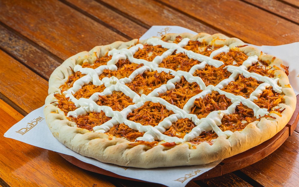 Illustrative photograph of BBQ chicken pizza with sauce and chicken toppings; not a photograph taken at McClain's Pizzeria